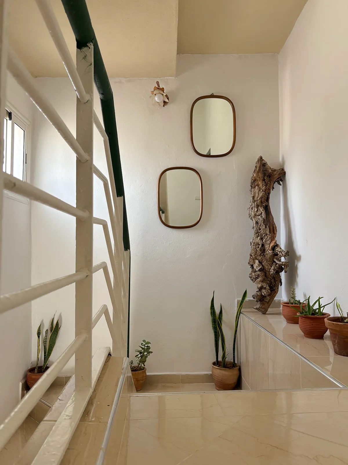 Staircase with mirrors at Taghazout Surf Villa, showcasing the surf-inspired interior design of the Moroccan retreat