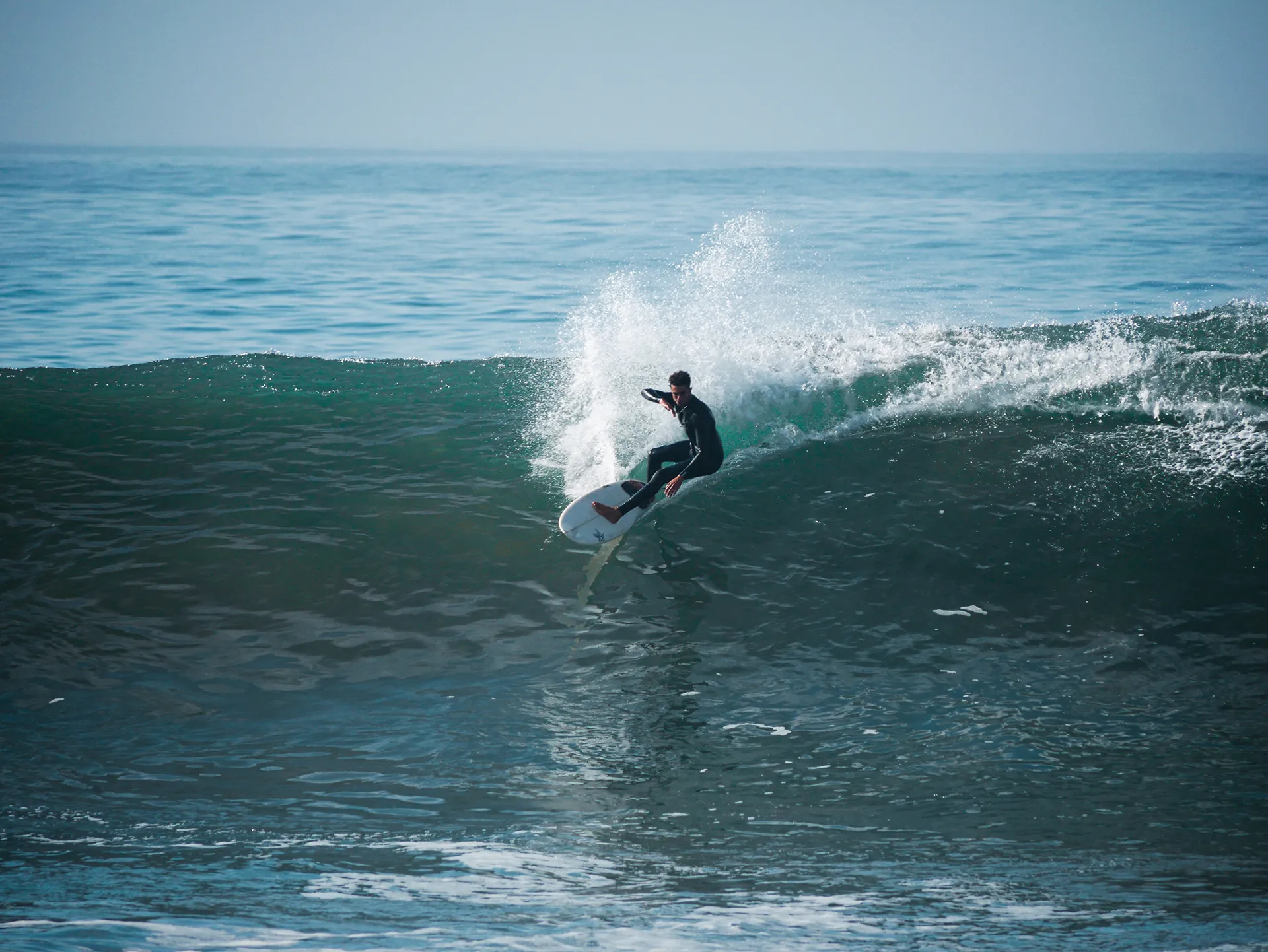 Surfer riding a wave in Taghazout with Taghazout Surf School during an all-inclusive surf camp in Morocco.