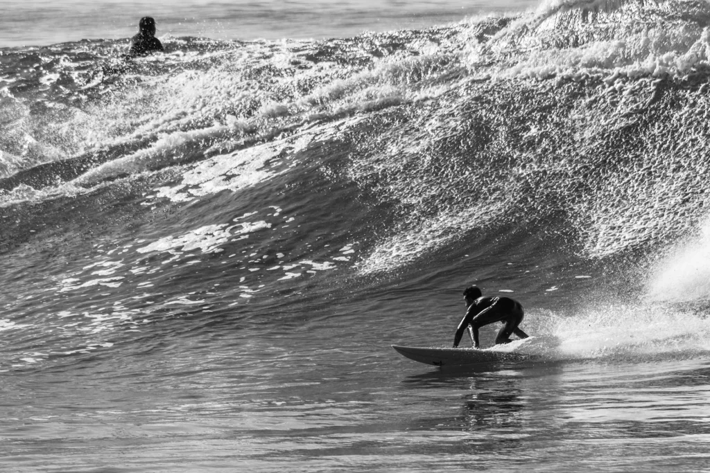 Surfers enjoying waves at Anchorpoint with Taghazout Surf Villa during an all-inclusive surf camp in Morocco, including surf lessons, yoga, and surfing in Morocco.
